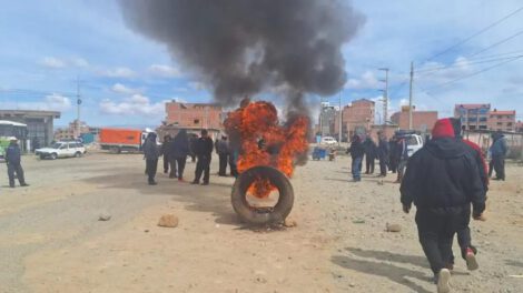 Incendio de un neumático y un grupo de personas