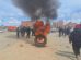 Incendio de un neumático y un grupo de personas