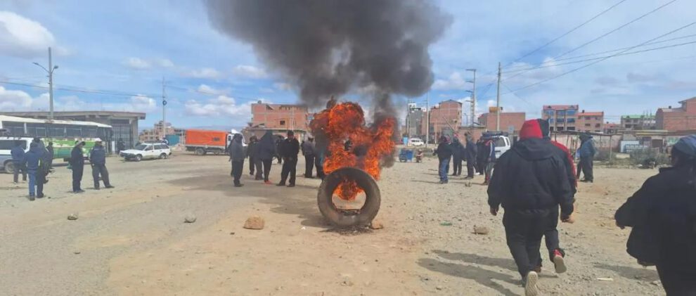 Incendio de un neumático y un grupo de personas