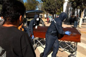 Familiares despiden el féretro con los restos de un fallecido, a las puertas del cementerio general de la ciudad de Cochabamba (Bolivia)