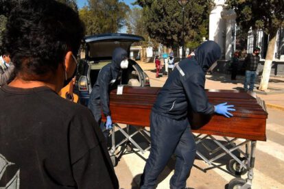 Familiares despiden el féretro con los restos de un fallecido, a las puertas del cementerio general de la ciudad de Cochabamba (Bolivia)