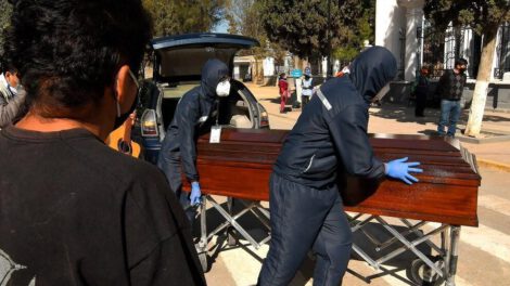 Familiares despiden el féretro con los restos de un fallecido, a las puertas del cementerio general de la ciudad de Cochabamba (Bolivia)
