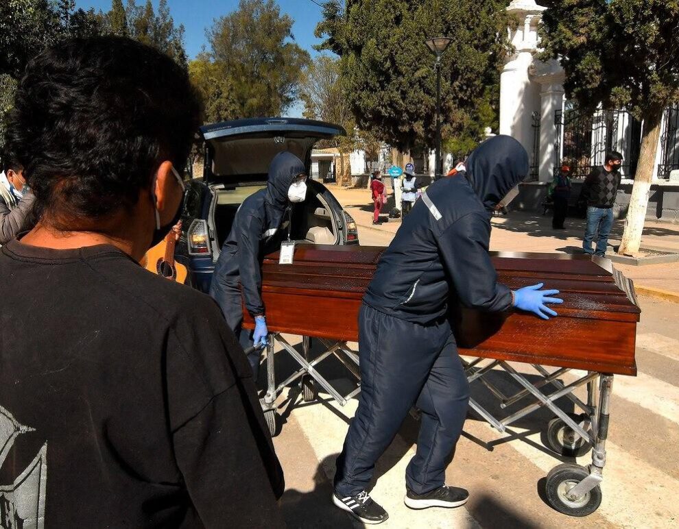Familiares despiden el féretro con los restos de un fallecido, a las puertas del cementerio general de la ciudad de Cochabamba (Bolivia)