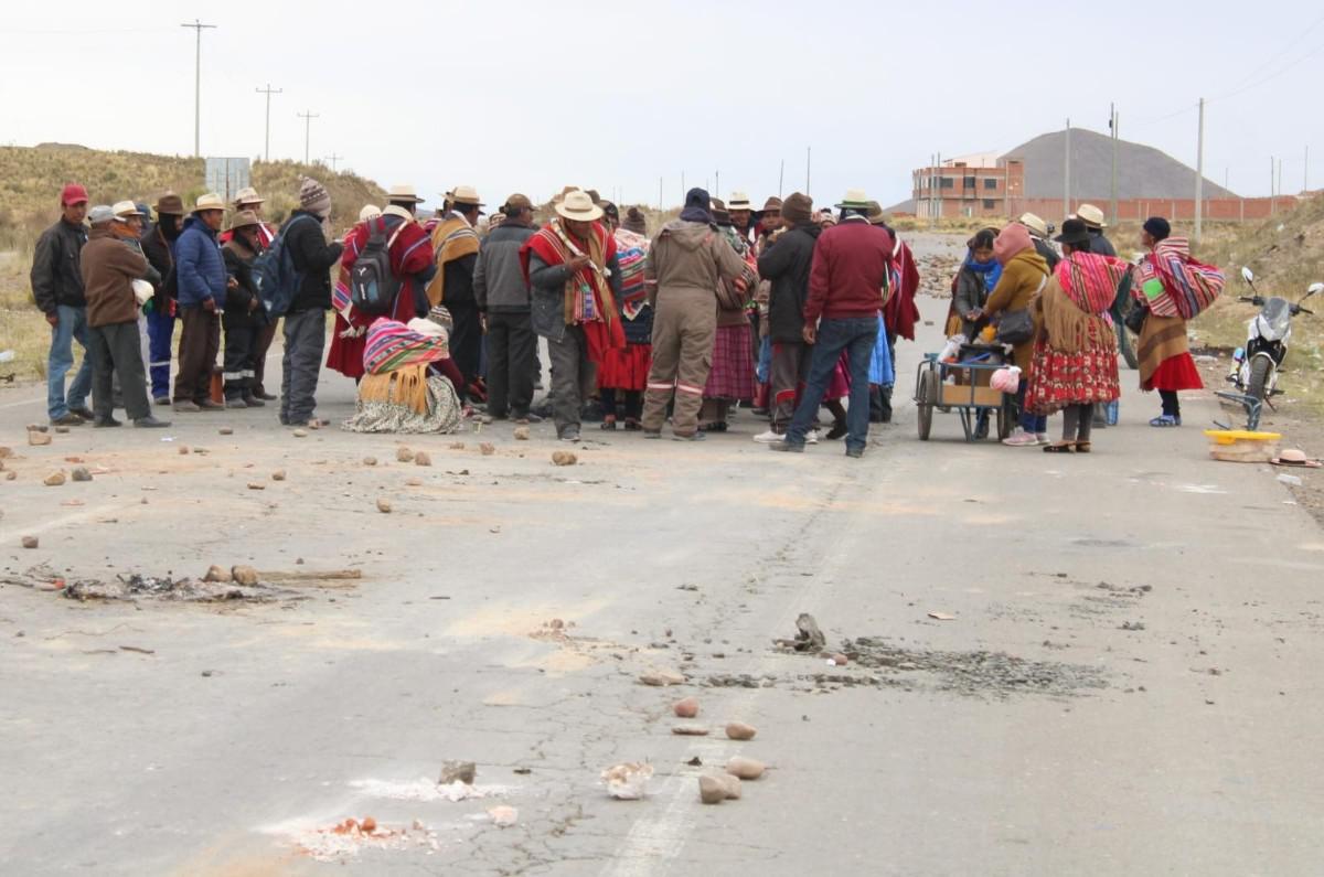 Un grupo de personas mantiene un corte de ruta con piedras y escombros