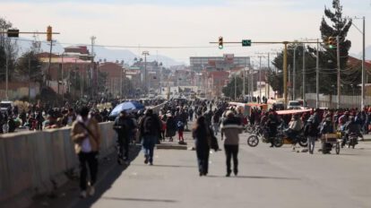 Personas caminan por una vía bloqueada