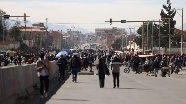 Personas caminan por una vía bloqueada