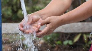 Una persona lavándose las manos en un grifo de agua