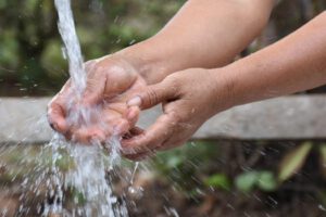 Una persona lavándose las manos en un grifo de agua