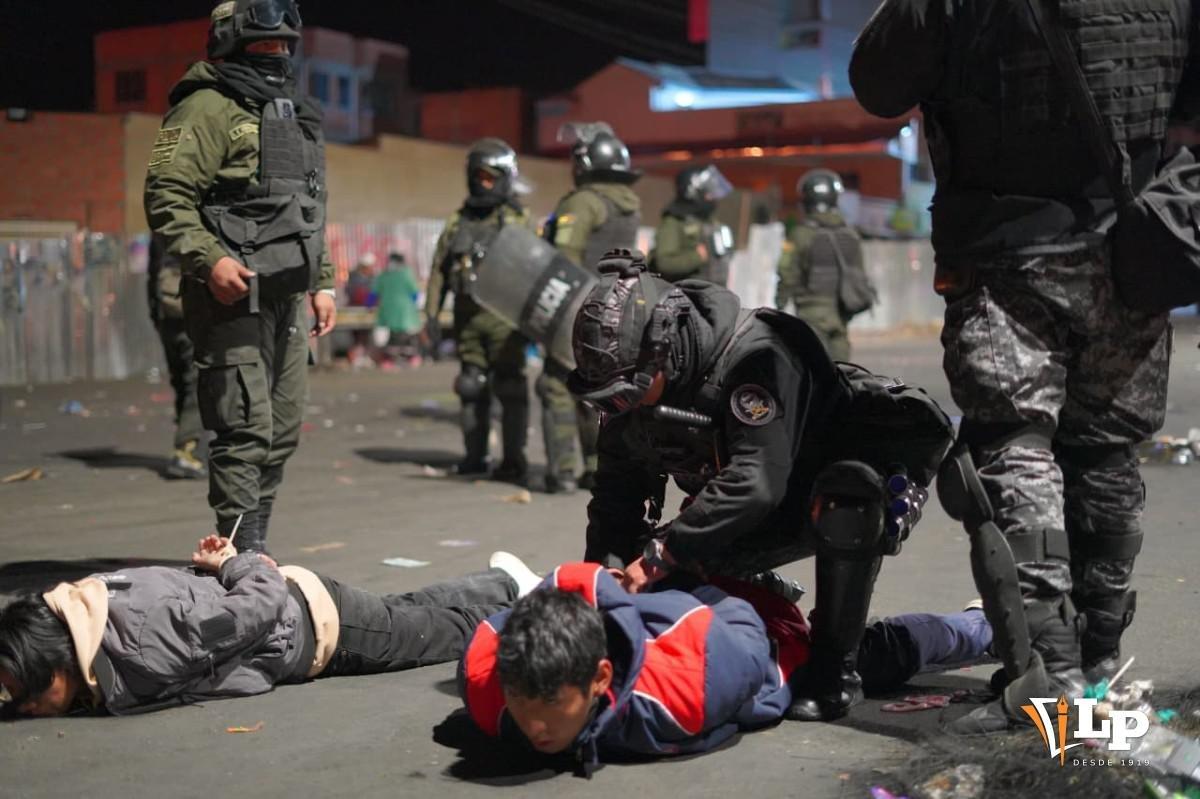 Policías reducen a dos civiles en el suelo tras los enfrentamientos registrados en la madrugada