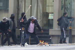 Un manifestante utiliza una honda durante los enfrentamientos con la policía