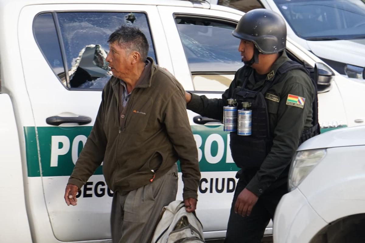Un agente de policía conduce a un detenido