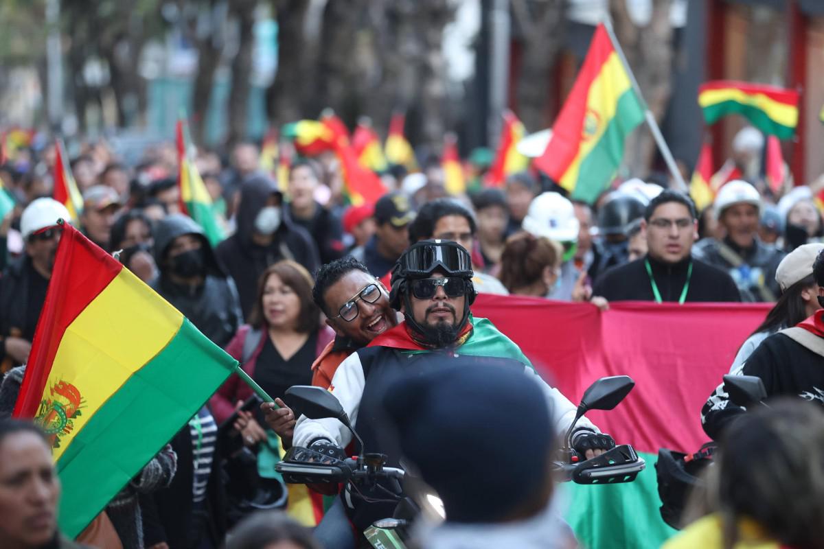 Manifestantes a bordo de una motocicleta acompañan la columna