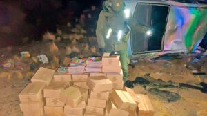 Un agente de seguridad examina el cargamento de álbumes y figuritas del Mundial 2026 hallado tras el accidente vehicular