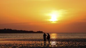 Personas pasean por una playa West Kirkby (Reino Unido), en una jornada calurosa