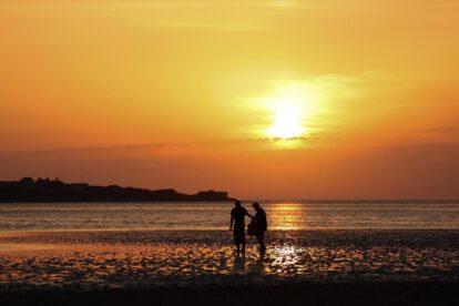 Personas pasean por una playa West Kirkby (Reino Unido), en una jornada calurosa