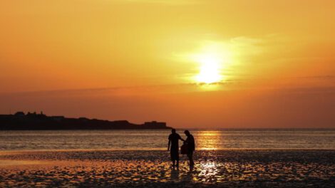 Personas pasean por una playa West Kirkby (Reino Unido), en una jornada calurosa