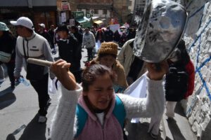 Una mujer marchando con una olla vacía