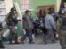 Un agente de la policía conduce a detenidos