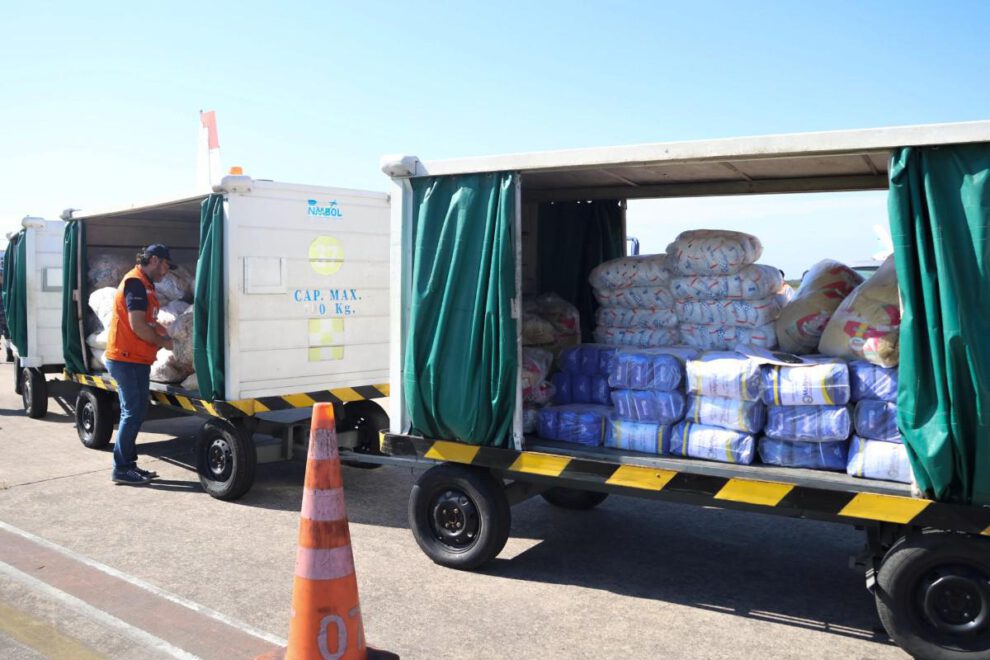Un integrante de la Defensa Civil de Bolivia descarga alimentos donados por Paraguay en Santa Cruz