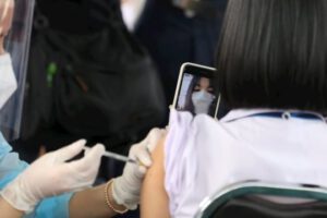 Personal médico inmunizando a un joven contra el Covid-19