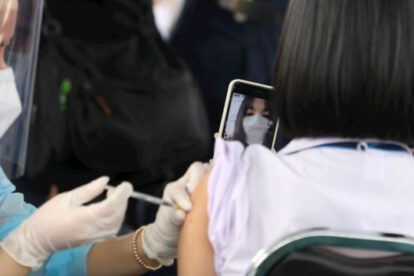 Personal médico inmunizando a un joven contra el Covid-19