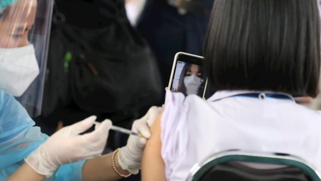 Personal médico inmunizando a un joven contra el Covid-19