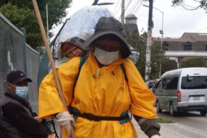 Nemecia limpia las calles junto a su pequeño hijo que lleva en la espalda