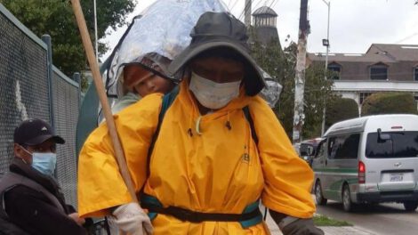 Nemecia limpia las calles junto a su pequeño hijo que lleva en la espalda