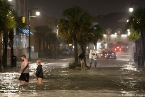 Personas caminan sobre las aguas en Carolina del Sur debido al huracán Isaías