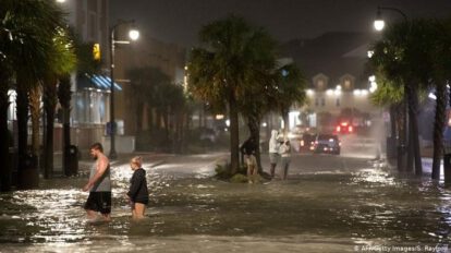 Personas caminan sobre las aguas en Carolina del Sur debido al huracán Isaías
