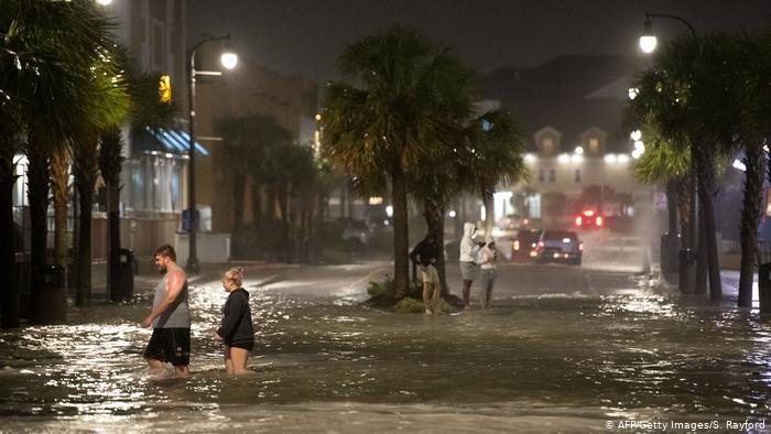 Personas caminan sobre las aguas en Carolina del Sur debido al huracán Isaías