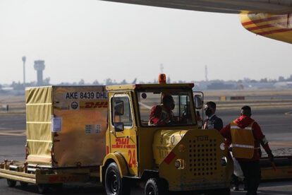 Trabajadores descargan contenedores con la vacuna Pfizer en la Ciudad de México