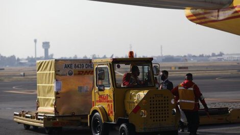 Trabajadores descargan contenedores con la vacuna Pfizer en la Ciudad de México