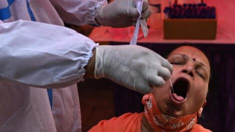 Un trabajador sanitario toma una muestra a una mujer para un test de coronavirus en India