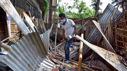 Hombre buscando algunas de sus pertenencias tras el sismo en India