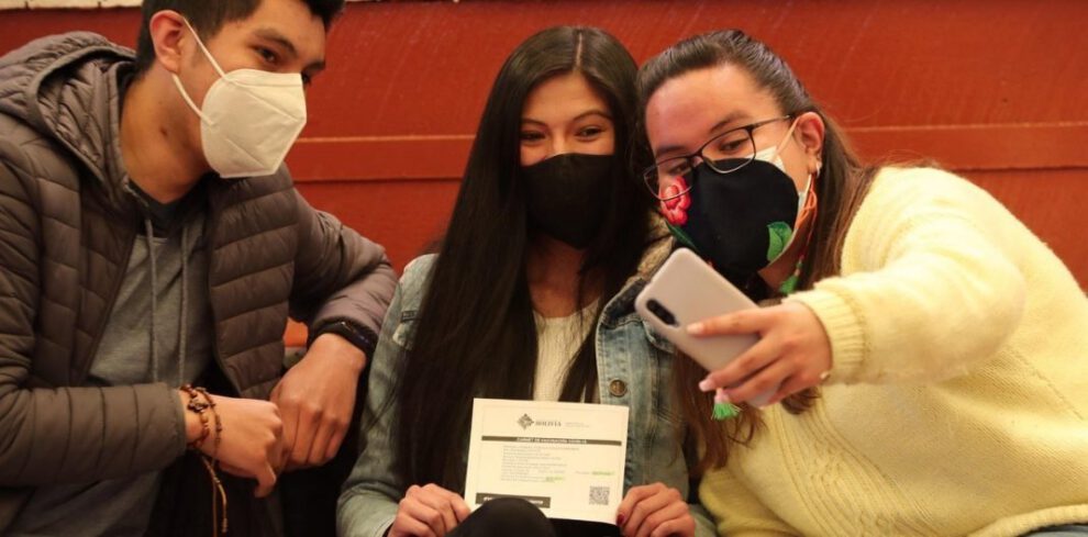 Jóvenes posan con certificado de vacunación Covid-19