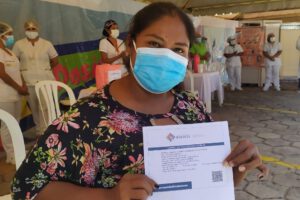 Mujer cruceña con su carnet de vacunación contra el Covid-19