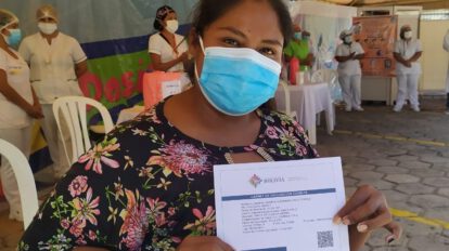 Mujer cruceña con su carnet de vacunación contra el Covid-19