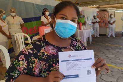 Mujer cruceña con su carnet de vacunación contra el Covid-19