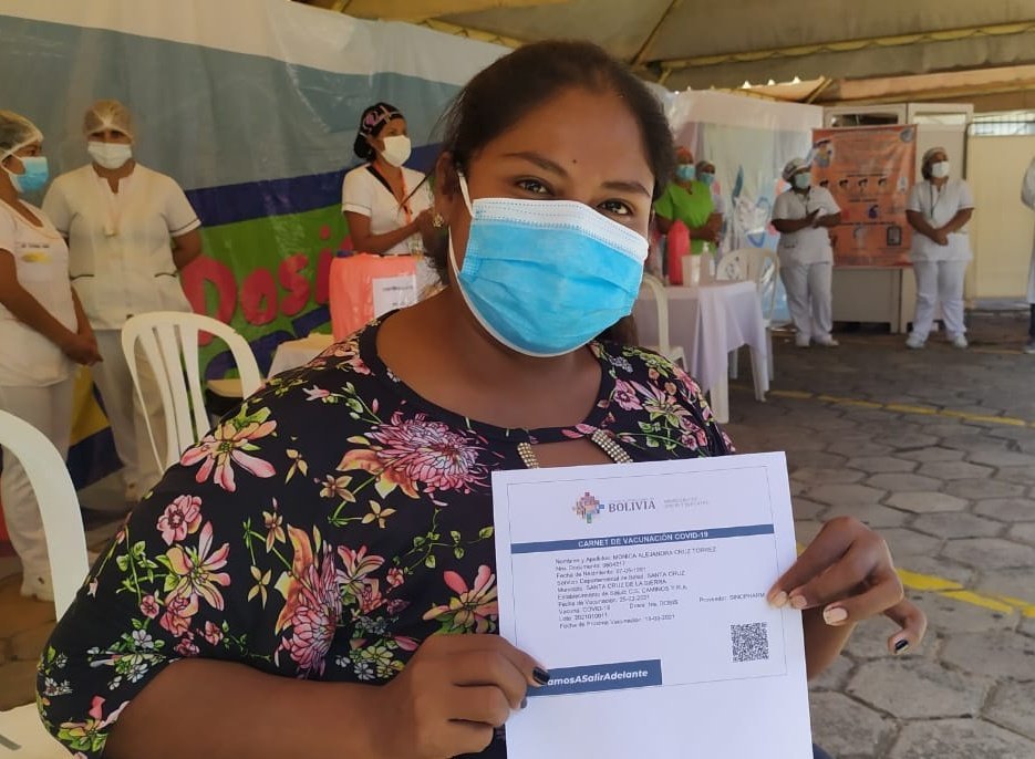 Mujer cruceña con su carnet de vacunación contra el Covid-19