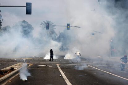 Manifestantes corren a través del gas lacrimógeno lanzado por agentes federales cerca de un Home Depot