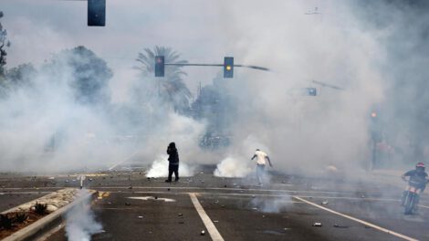Manifestantes corren a través del gas lacrimógeno lanzado por agentes federales cerca de un Home Depot