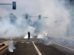 Manifestantes corren a través del gas lacrimógeno lanzado por agentes federales cerca de un Home Depot