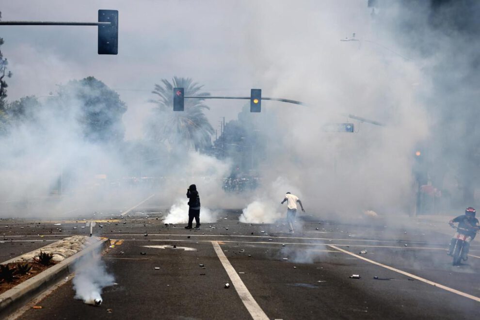 Manifestantes corren a través del gas lacrimógeno lanzado por agentes federales cerca de un Home Depot