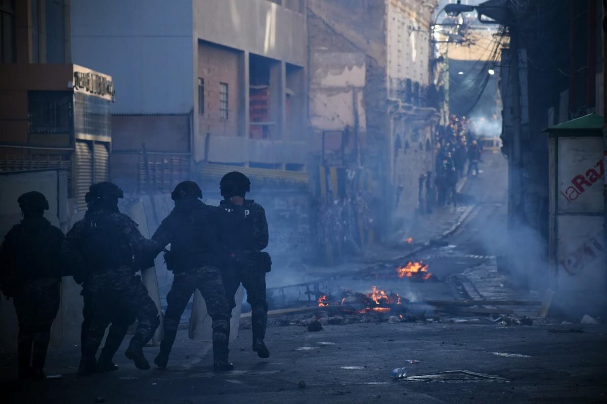 Agentes de la policía se despliegan en una zona con barricadas incendiadas durante las protestas