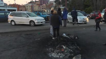 Personas paradas y autos