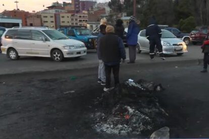 Personas paradas y autos