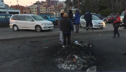 Personas paradas y autos