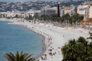 personas disfrutan del sol en una playa de Niza, Francia