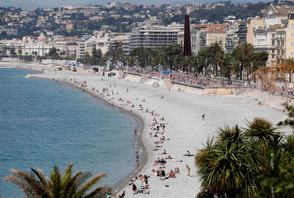 personas disfrutan del sol en una playa de Niza, Francia